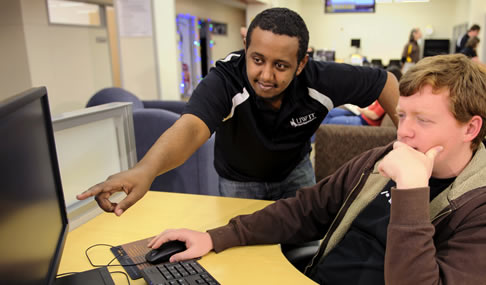 photograph of ATS employee helping a computer lab user